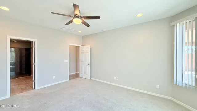 an empty room with ceiling fan and window