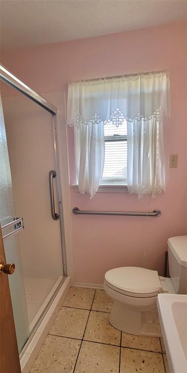 7813 Pebbleford Road Fort Worth, TX 76134 - Photo 16 of 23 a bathroom with a toilet and a shower