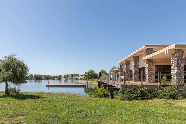 a view of a swimming pool with a lawn chairs and palm trees