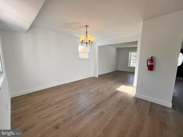an empty room with wooden floor and window