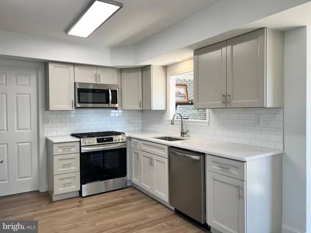 a kitchen with stainless steel appliances granite countertop a sink stove and microwave