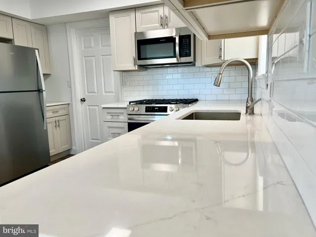 a kitchen with stainless steel appliances granite countertop a sink a stove a microwave and cabinets