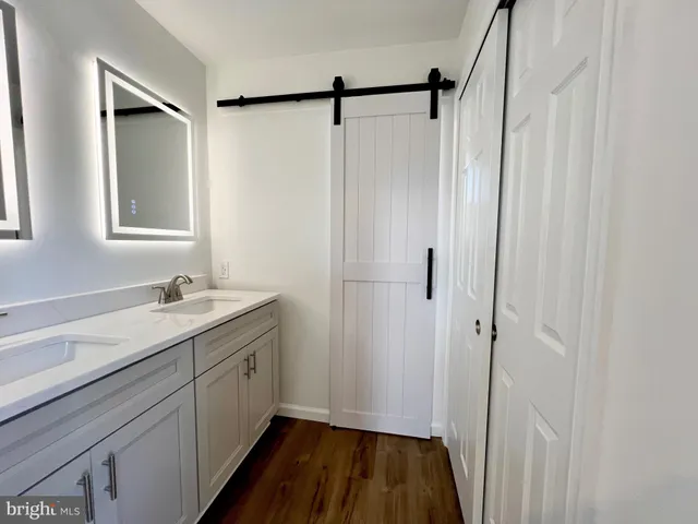 a bathroom with a granite countertop sink mirror and a shower