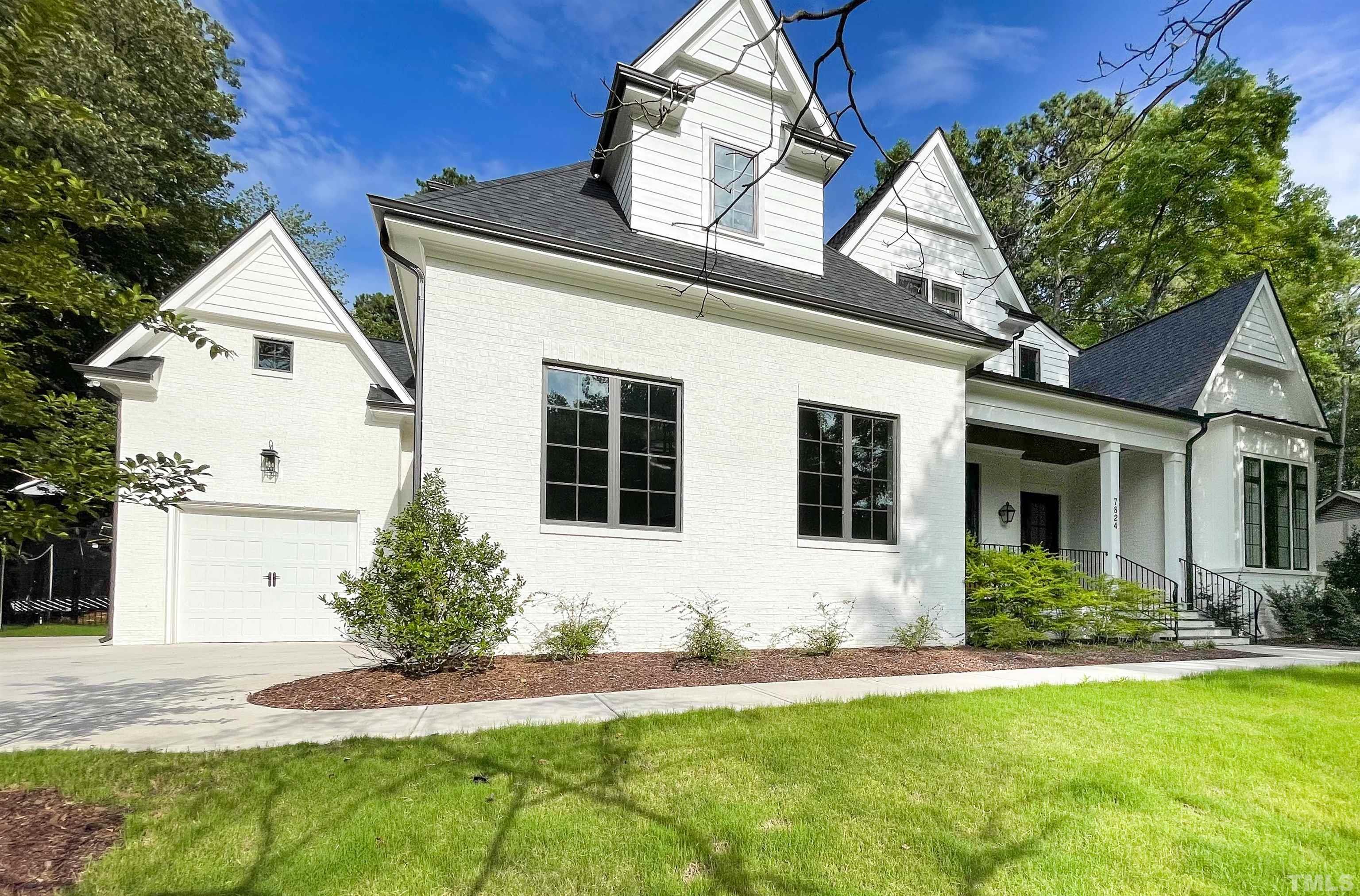 7824 Harps Mill Road Raleigh, NC 27615 - Photo 1 of 17 a front view of a house with a yard and garage