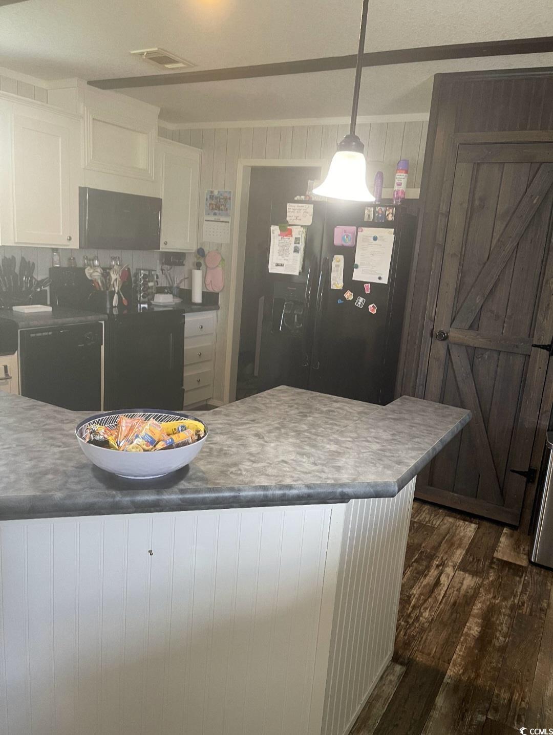 2470 Wigley Road Loris, SC 29569 - Photo 7 of 30 Kitchen with white cabinets, a peninsula, black appliances, decorative light fixtures, and dark wood finished floors