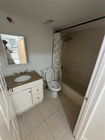 a spacious bathroom with a granite countertop sink a toilet and a shower