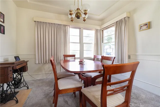 a view of a dining room with furniture and a chandelier