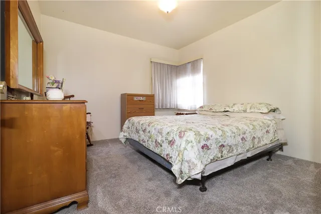a bedroom with a bed lamp and a window