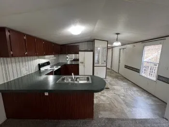 a kitchen with kitchen island granite countertop a stove a refrigerator a sink dishwasher with a dining table and chairs with wooden floor