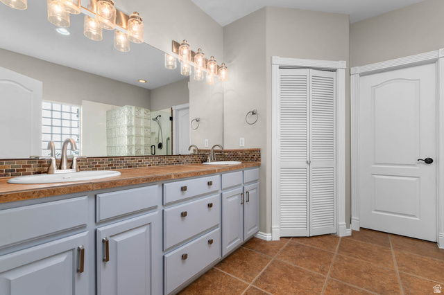 1417 Blacksmith Lane Draper, UT 84020 - Photo 23 of 57 Dual vanity with integrated sinks and brushed nickel faucets, set against a mosaic tile backsplash