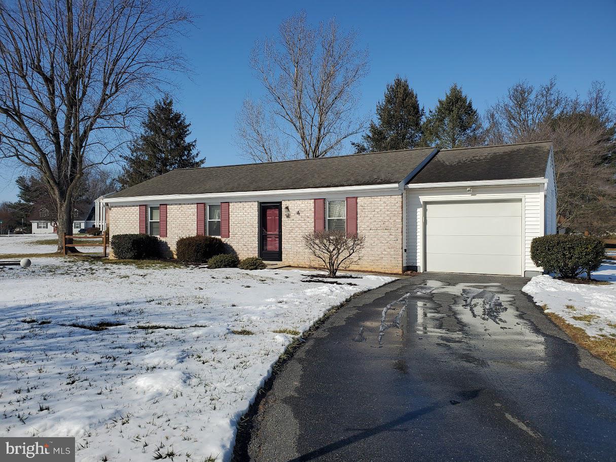 a front view of a house with a yard covered in snow