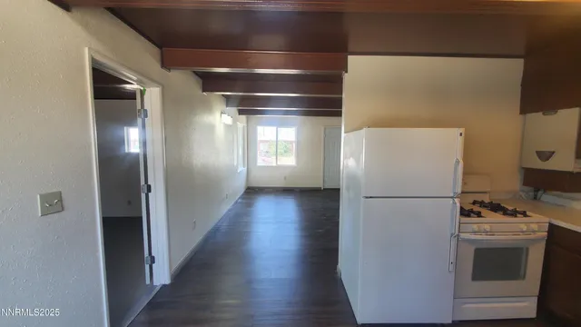 a view of kitchen with refrigerator and wooden floor