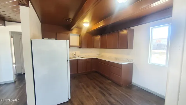 a kitchen with a refrigerator a stove top oven a sink and dishwasher with wooden floor