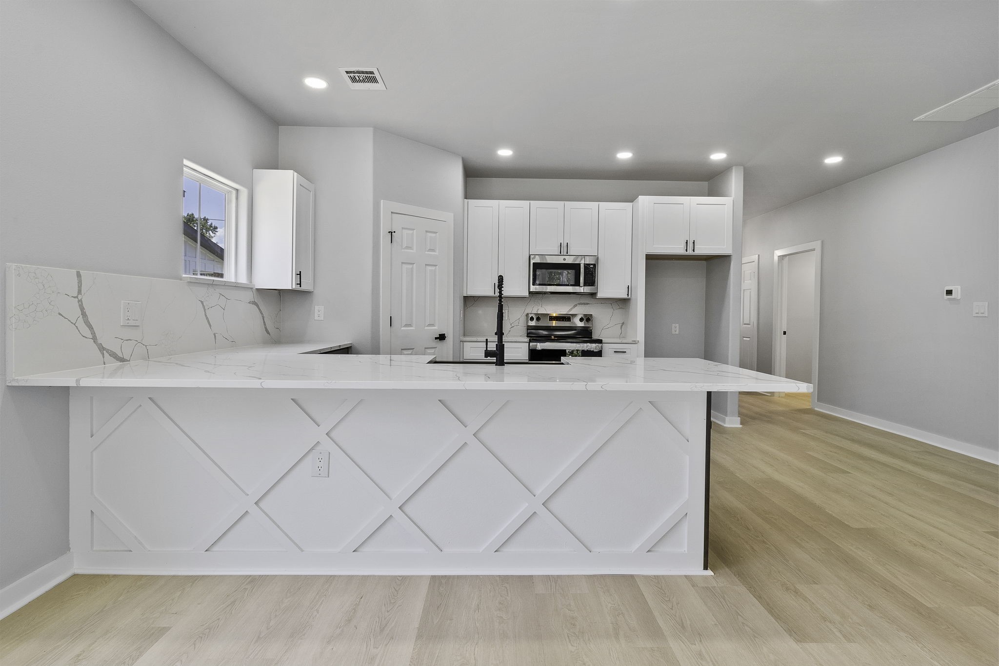 599 Bridgeview Drive Onalaska, TX 77360 - Photo 11 of 27 a large white kitchen with kitchen island white cabinets and stainless steel appliances