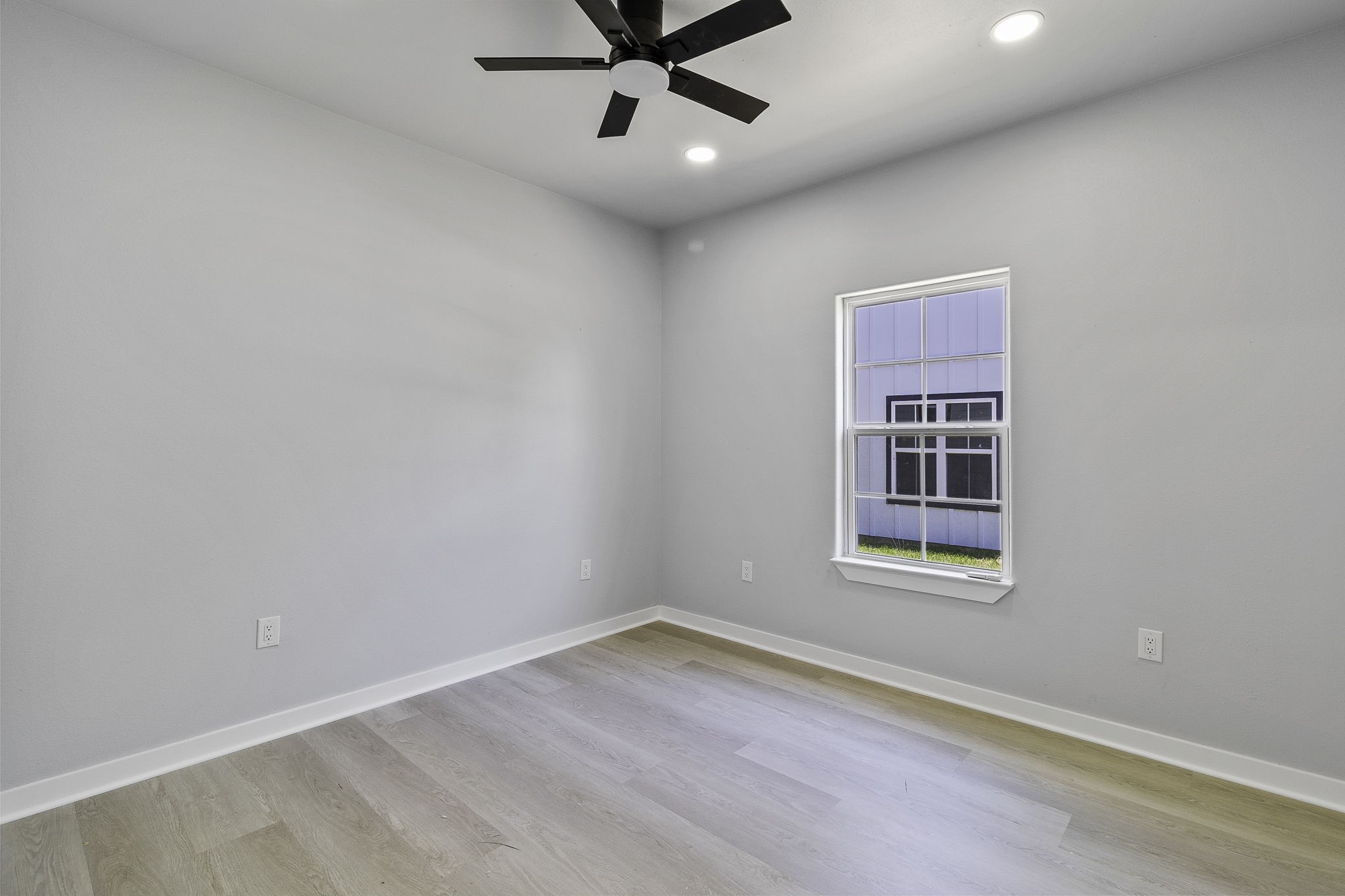 599 Bridgeview Drive Onalaska, TX 77360 - Photo 20 of 27 an empty room with wooden floor ceiling fan and windows