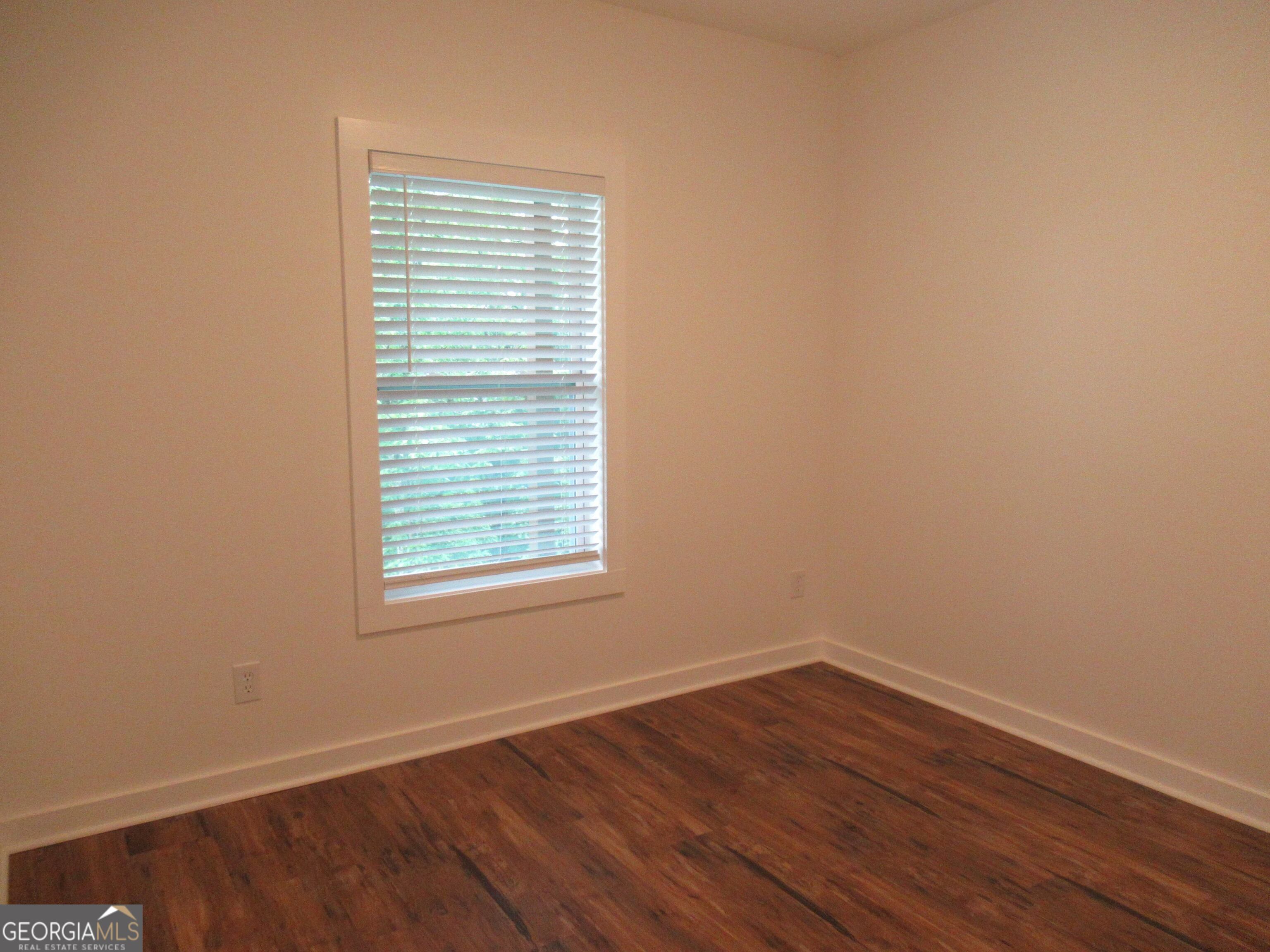 765 Old Kerns Road Dawsonville, GA 30534 - Photo 35 of 36 an empty room with wooden floor and a window