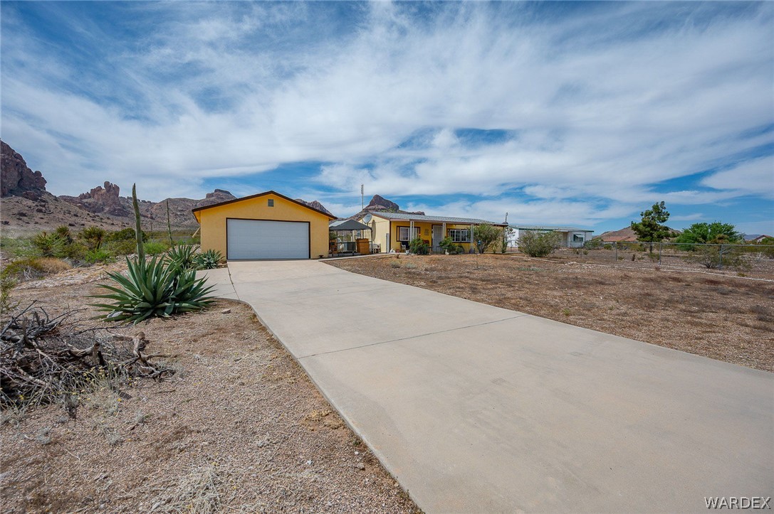 2465 Egar Road Golden Valley, AZ 86413 - Photo 6 of 98 The property features a yellow-painted detached garage with a white garage door