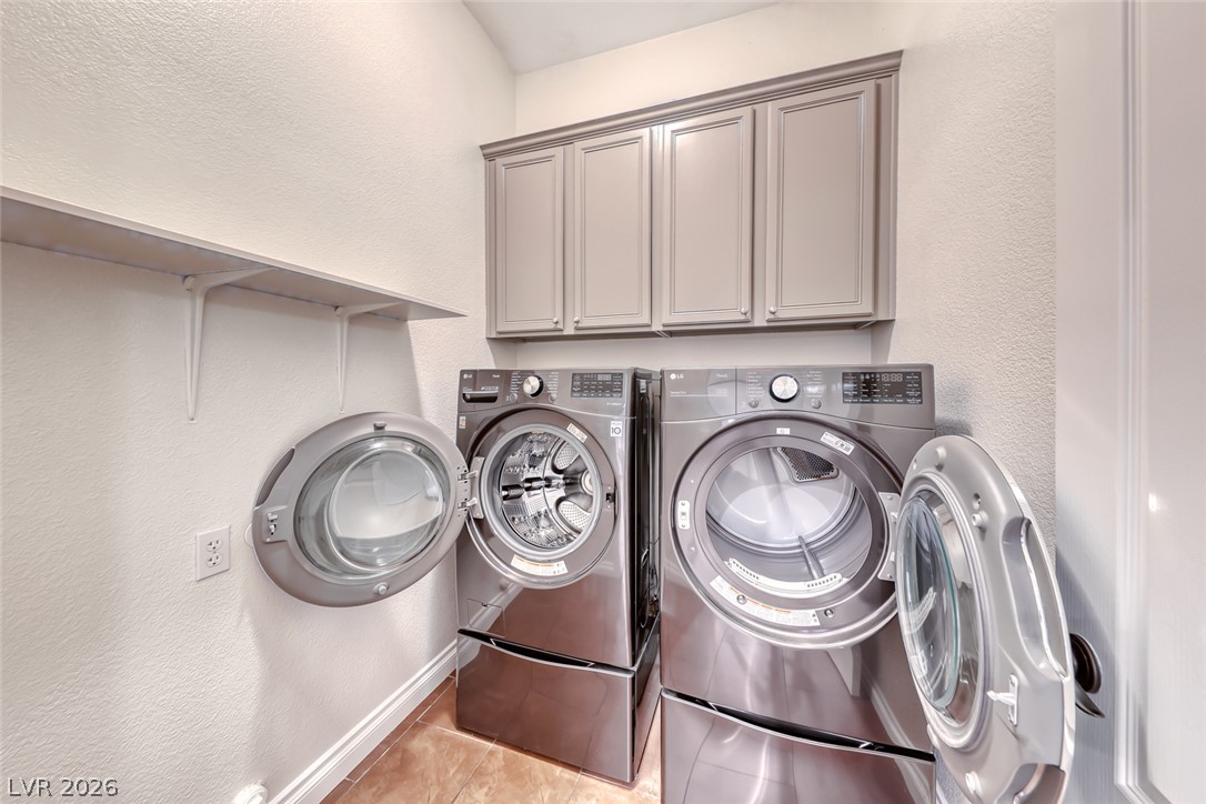 2122 Mooreview Street Henderson, NV 89012 - Photo 32 of 44 A well-appointed utility area features a full-size washer and dryer with convenient overhead cabinetry.