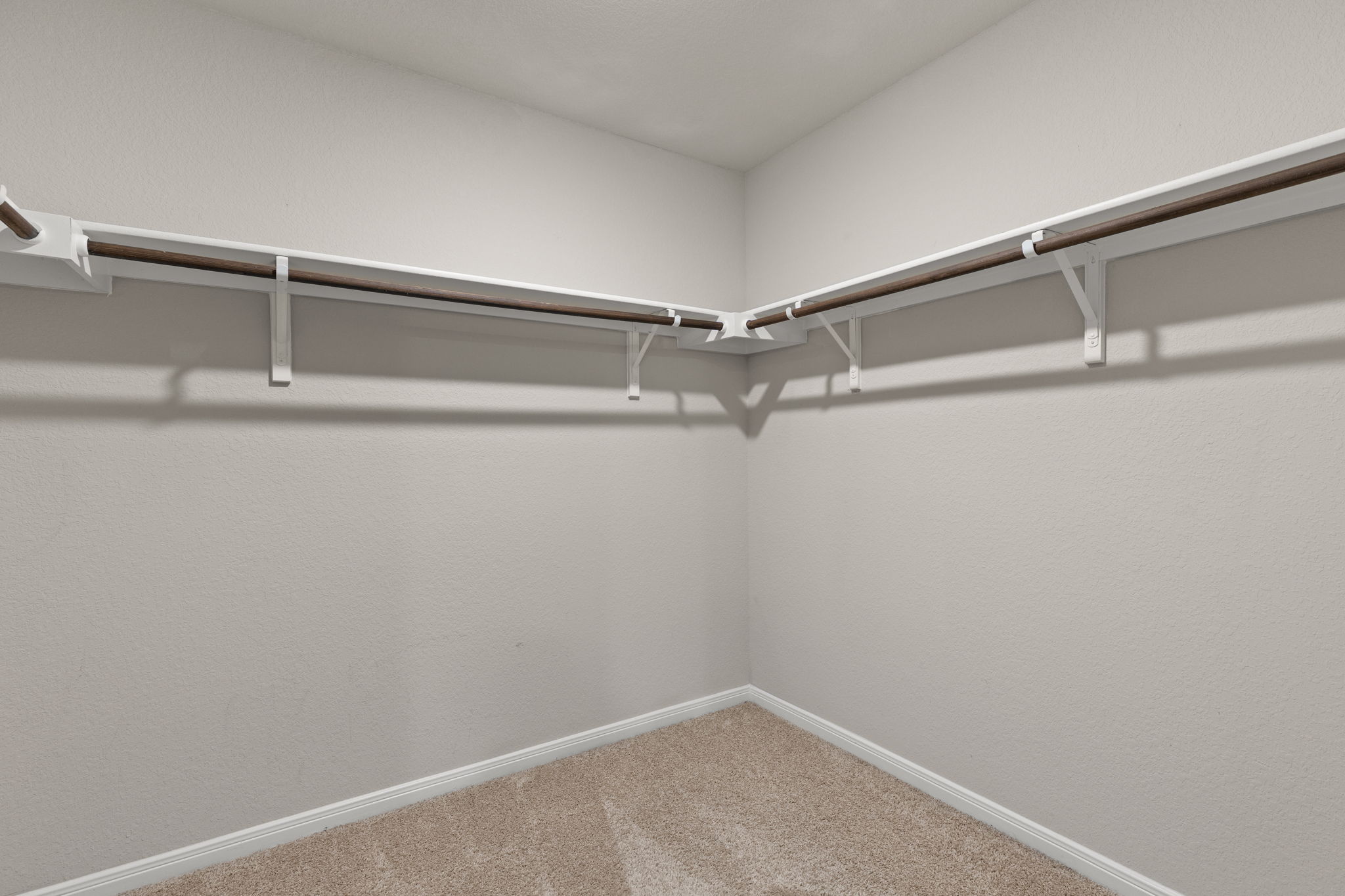281 Jayden Drive Kyle, TX 78640 - Photo 25 of 36 Walk-in closet featuring light-colored walls, wall-to-wall carpeting, white baseboards, and built-in white shelving with wood-finish rods