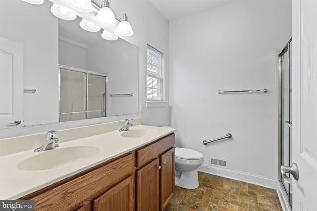 a bathroom with a sink a toilet and a mirror