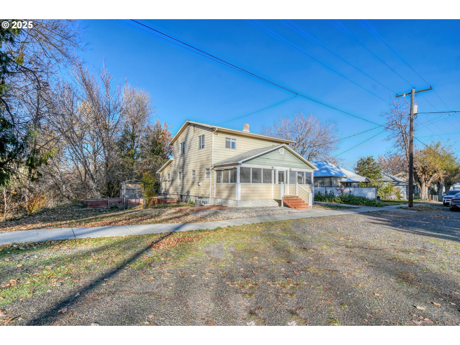 a view of a house next to a big yard with large trees