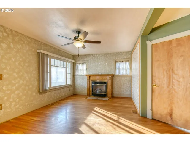 a view of an empty room with a fireplace and a window