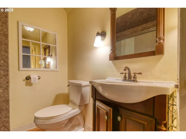 a bathroom with a sink toilet and mirror