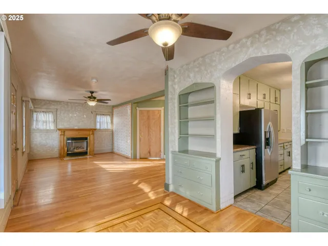 a view of a livingroom with a fireplace a chandelier and stairs