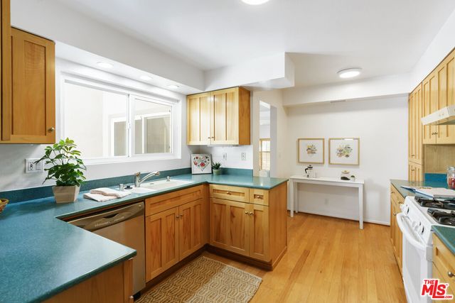 a kitchen with a sink stove and wooden cabinets