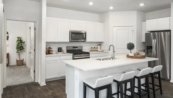a kitchen with stainless steel appliances kitchen island granite countertop a dining table and chairs
