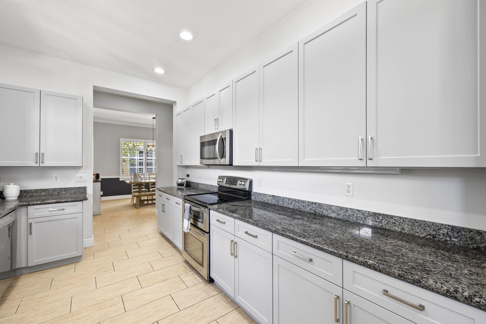 202 Botanica Drive Jupiter, FL 33458 - Photo 11 of 33 a kitchen with granite countertop a sink a stove and cabinets