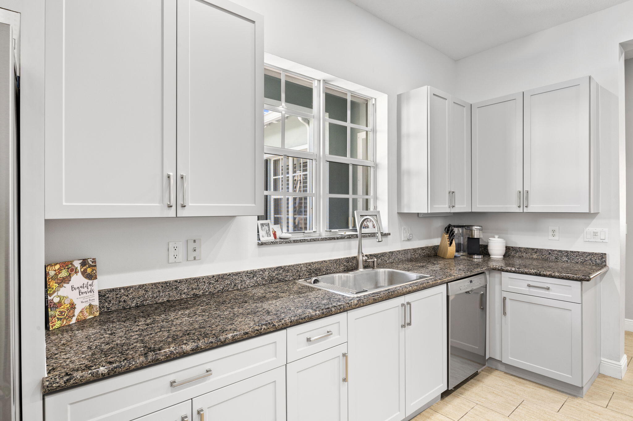 202 Botanica Drive Jupiter, FL 33458 - Photo 12 of 33 a kitchen with granite countertop white cabinets and white stainless steel appliances