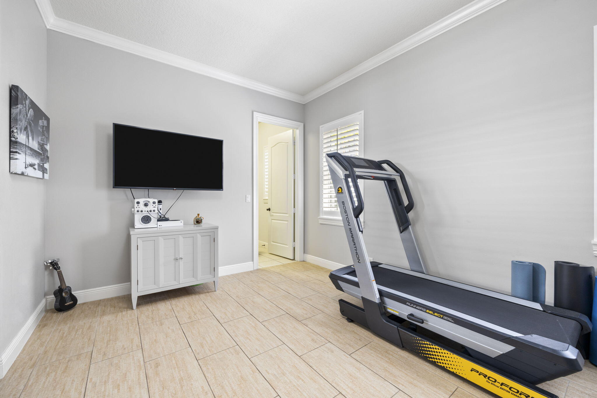 202 Botanica Drive Jupiter, FL 33458 - Photo 15 of 33 a room with gym equipment and a flat screen tv