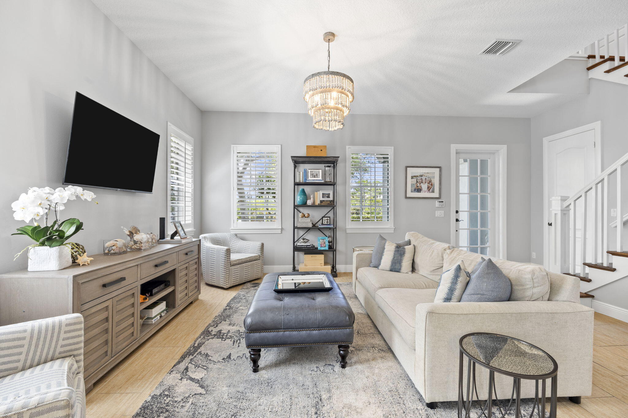 202 Botanica Drive Jupiter, FL 33458 - Photo 6 of 33 a living room with furniture a flat screen tv and a floor to ceiling window