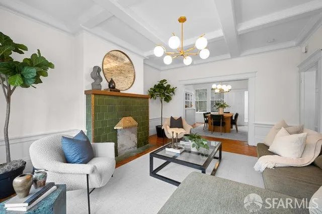 a living room with furniture a chandelier a rug and a mirror