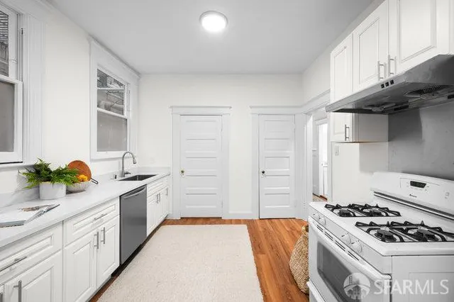a kitchen with stainless steel appliances a stove a sink and a refrigerator