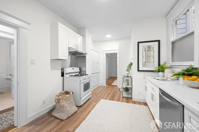 a large white kitchen with cabinets and stainless steel appliances