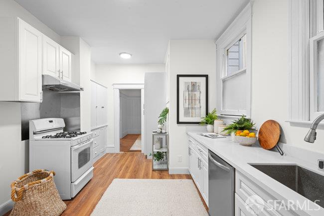 1108-1112 Pine Street San Francisco, CA 94109 - Photo 24 of 53 a kitchen with a sink stove and cabinets