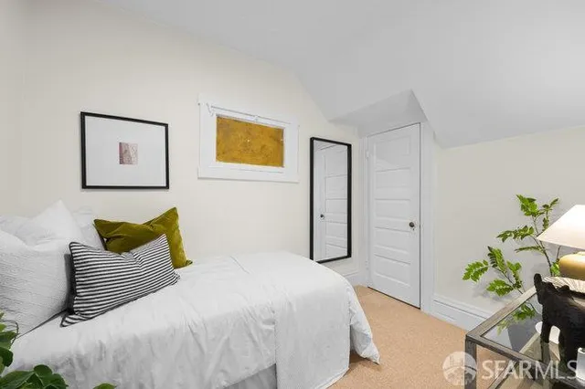 a bedroom with a bed and painting on the wall