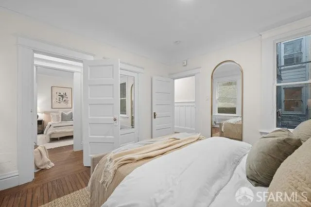 a bedroom with a bed and a large mirror