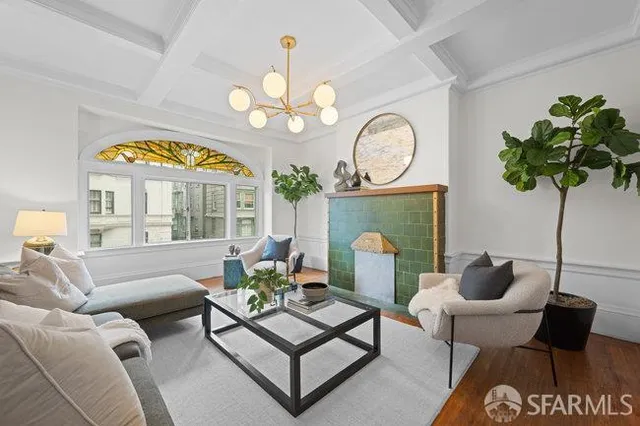 a living room with furniture a chandelier and a large window