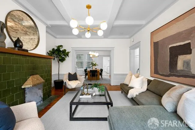a living room with furniture a chandelier and a mirror