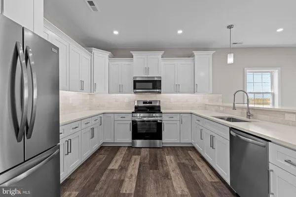 a kitchen with granite countertop white cabinets and stainless steel appliances