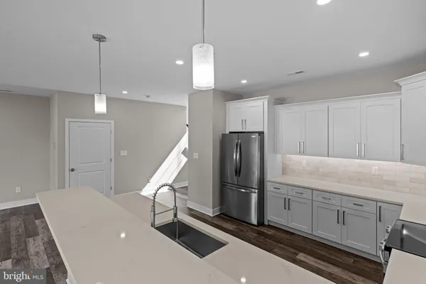 a kitchen with refrigerator cabinets and wooden floor