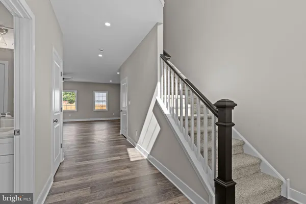 a view of a hallway with wooden floor and stairs