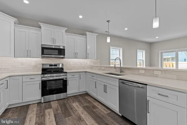 a kitchen with granite countertop a sink stainless steel appliances and cabinets