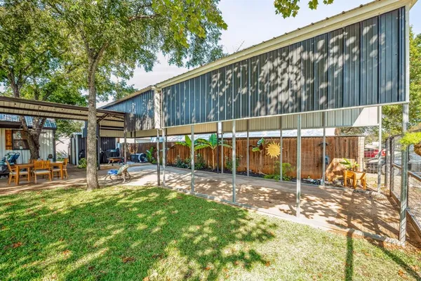 a view of a chairs and table in backyard