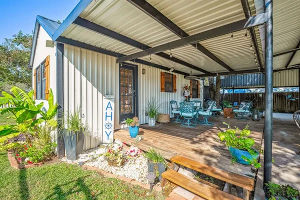 a view of a patio with table and chairs potted plants with wooden floor and fence