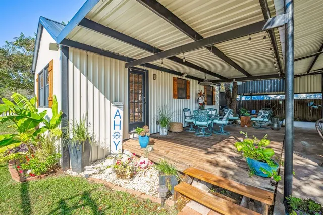 a view of a patio with table and chairs potted plants with wooden floor and fence