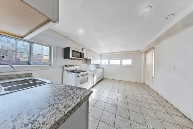 a kitchen with a stove a sink and a microwave